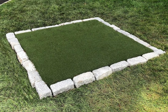 Asheville Tee box made of synthetic grass surrounded by stone border
